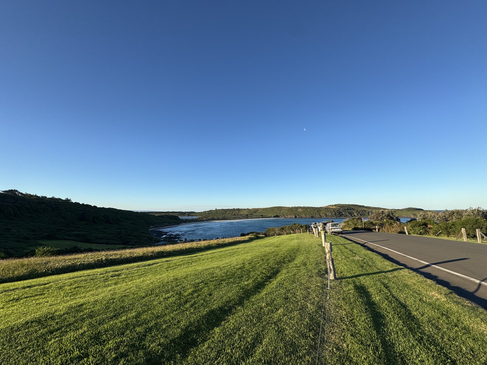 Coastal road through green hills